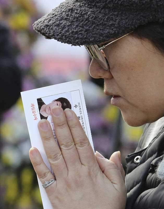 A mother prays during a special service to wish for her son's success in an upcoming college entrance exam at Jogye Temple in Seoul.