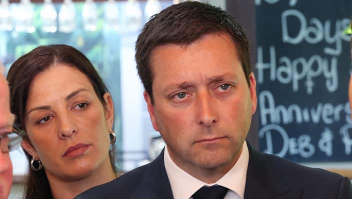 Victorian Leader of the Opposition Matthew Guy speaks to the media while his wife Renae Guy (left) watches on  Monday, November 19, 2018. 