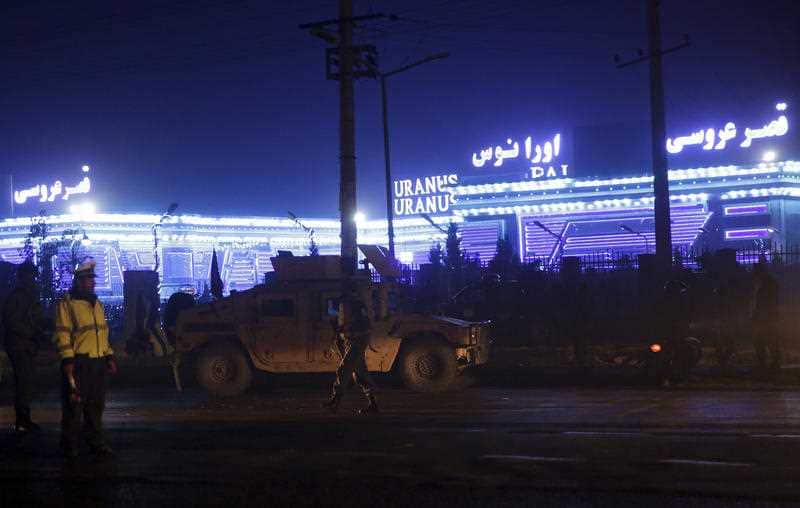 Security forces inspect a wedding hall in Kabul, the site of the suicide attack
