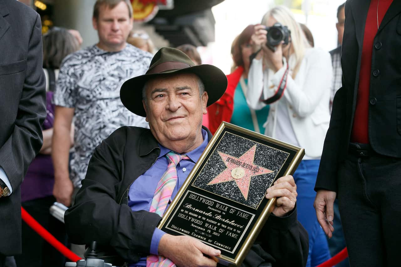Italian director Bernardo Bertolucci holds a star plaque at a ceremony in his honor as he makes a rare visit to his star on the Hollywood Walk of Fame.