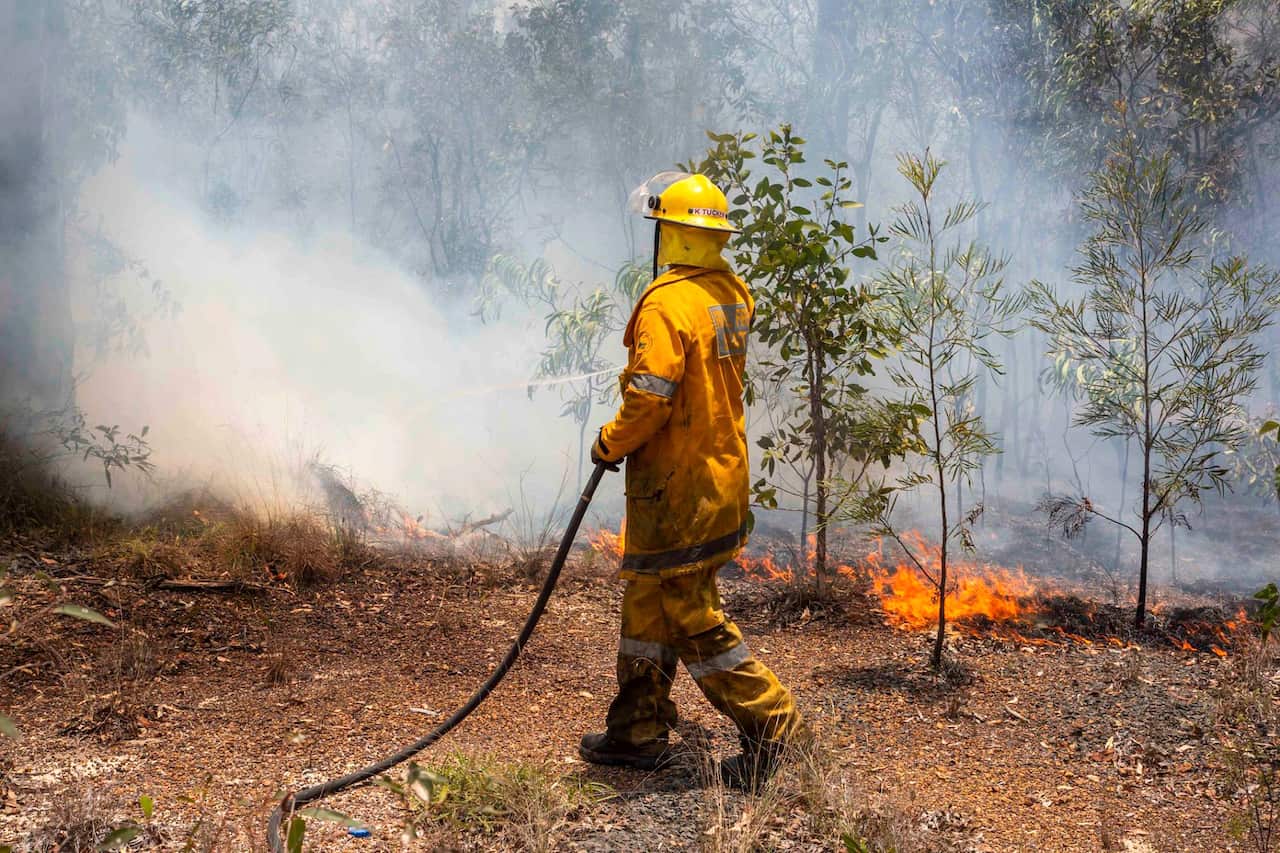 A firefighter works on a fire ground at Deepwater, near Bundaberg, Australia. 