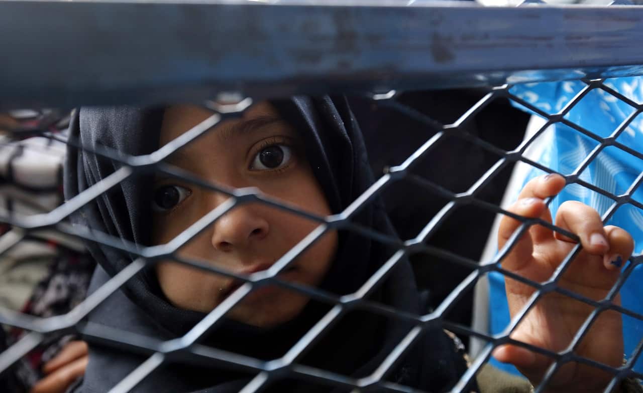 A conflict-affected Yemeni child waits to receive free bread by a local charity.