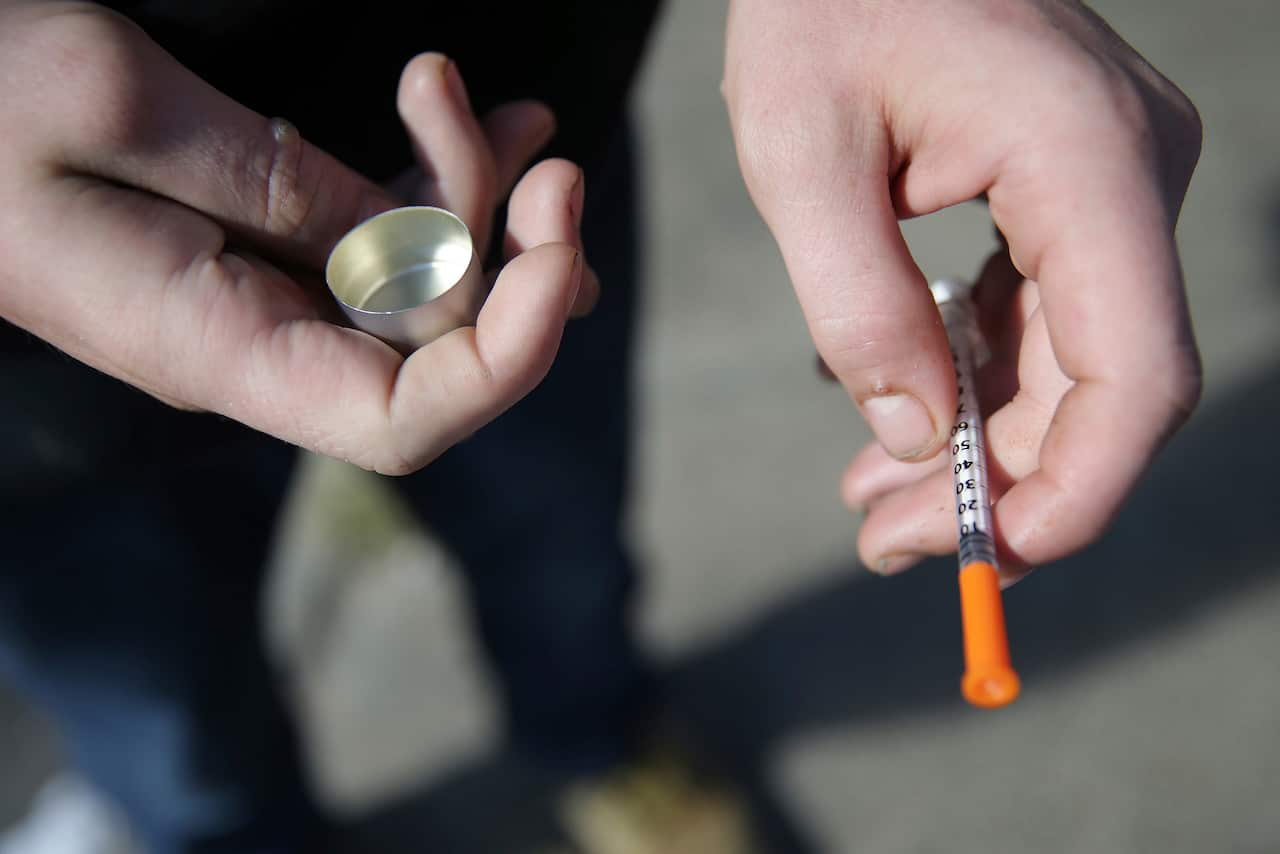 A fentanyl user who didnt want to be identified holds a needle.