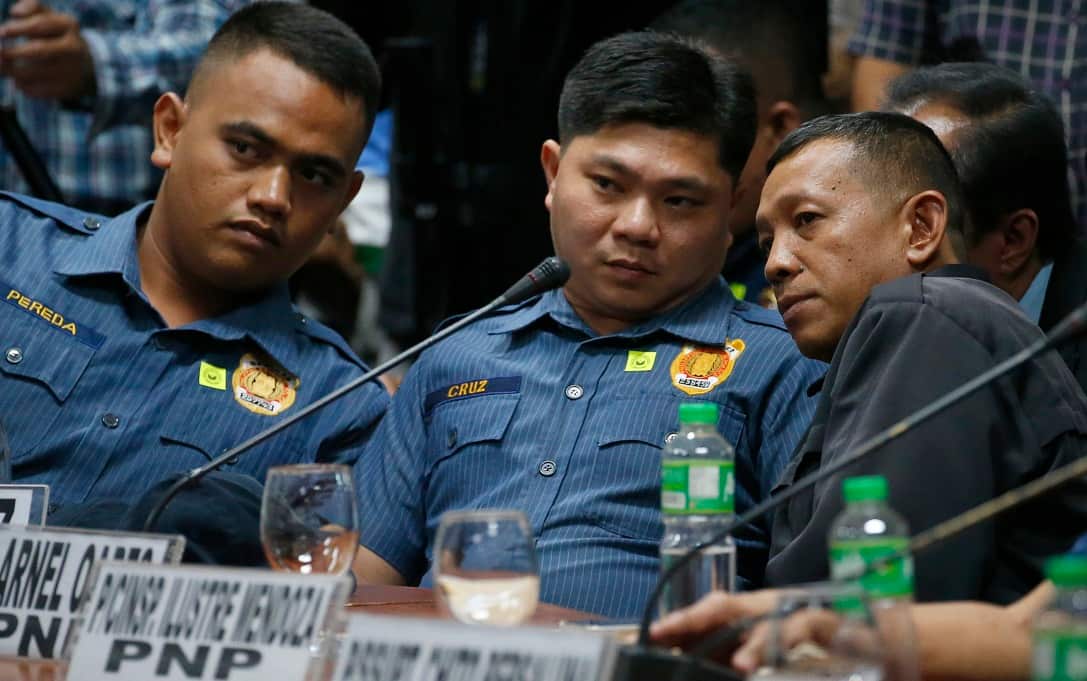Police officers talk during a senate hearing on the killing of Kian Loyd Delos Santo.