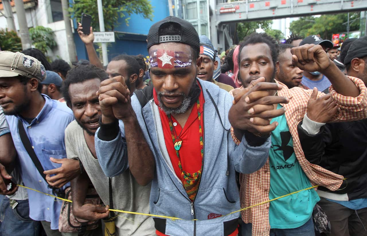 Papuan activists with his forehead painted with banned separatist flag the "Morning Star" march in Surabaya, East Java, Indonesia.