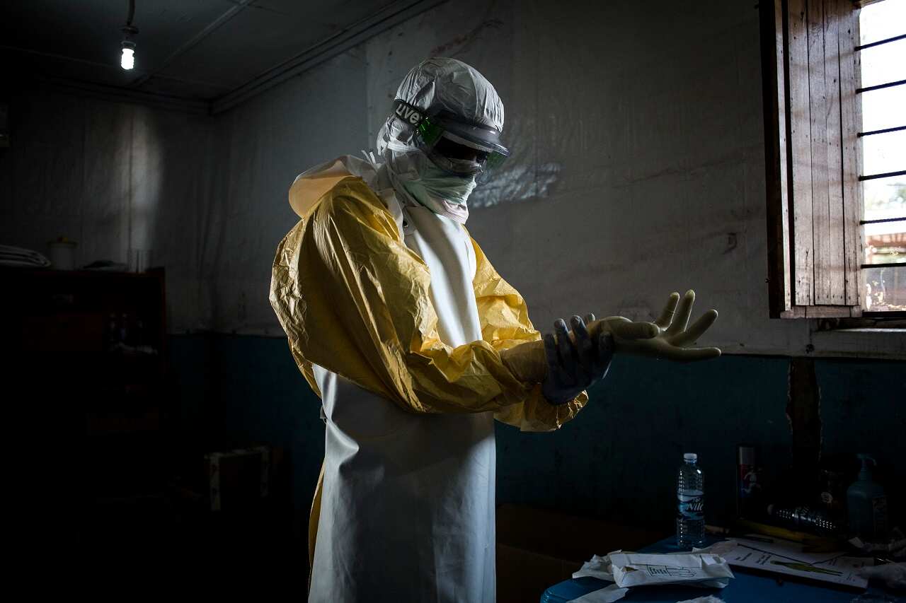 A health worker put on his personal protective equipment before entering a "red zone".