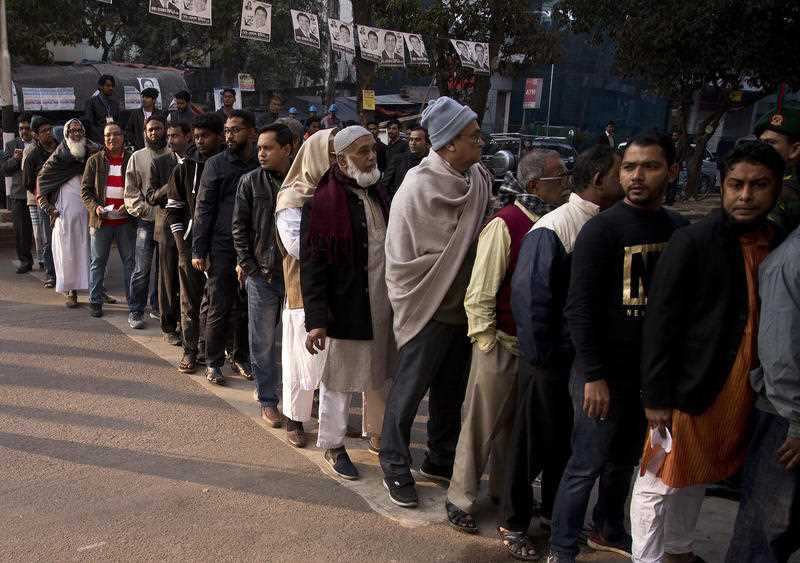 Bangladeshi men line up to cast their vote at a polling station in Dhaka.