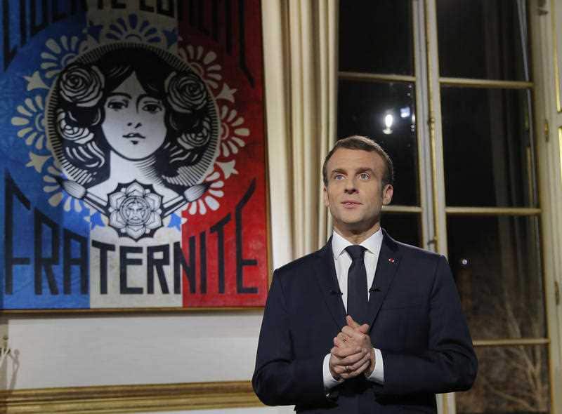 French President Emmanuel Macron poses for a photograph after delivering his New Year wishes