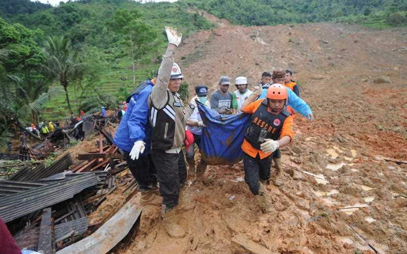 Indonesian rescuers carry the remains of a landslide victim at Sirnaresmi village in Sukabumi, Indonesia.