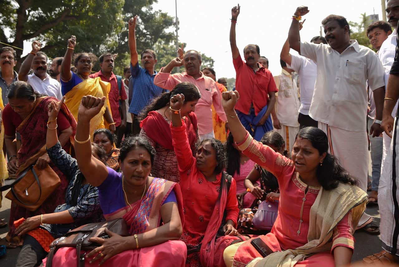 Protesters block traffic after two women of menstruating age entered the Sabarimala temple.