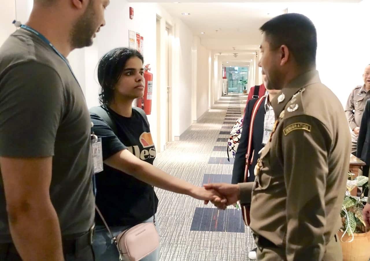 Rahaf Mohammed Al-Qunun shakes hands with Thai Immigration Police Chief Surachet Hakparn.