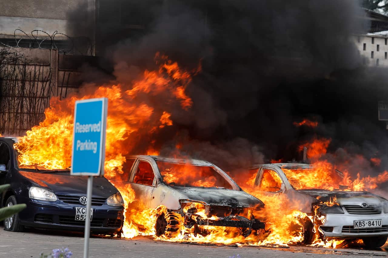 Cars burn at the parking lot during an ongoing gunfire and explosions in Nairobi, Kenya.