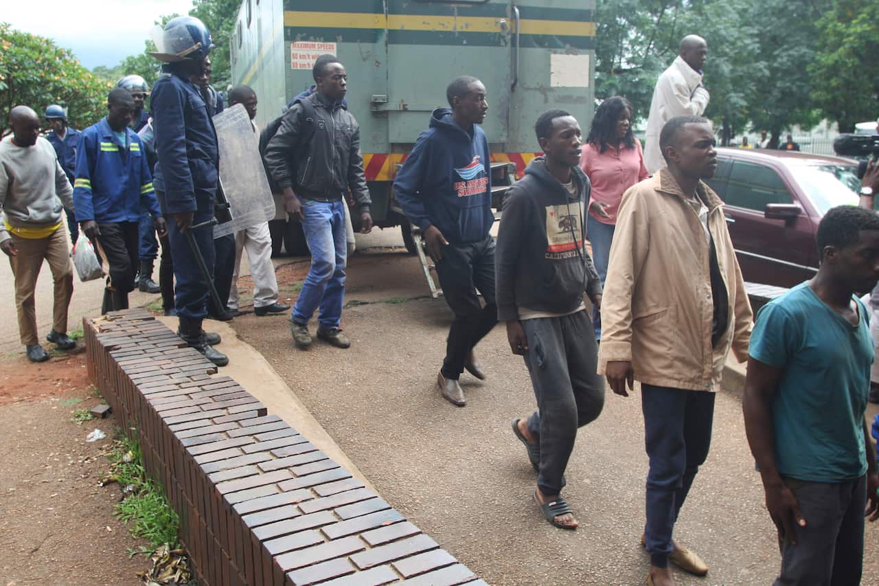 A policeman stands guard as some of the people arrested during demonstrations over the hike in fuel prices.