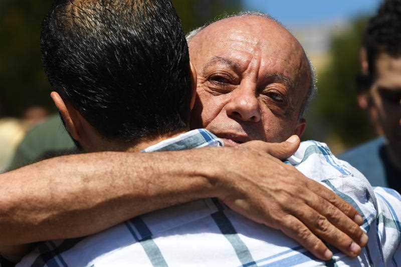 Saeed Maasarwe recieves a hug from a mourner at the vigil held at the site where the body of his daughter was found in Bundoora.