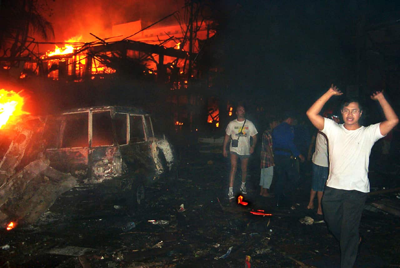 Residents and foreign tourists evacuate the scene of a bomb blast in Bali in 2002.