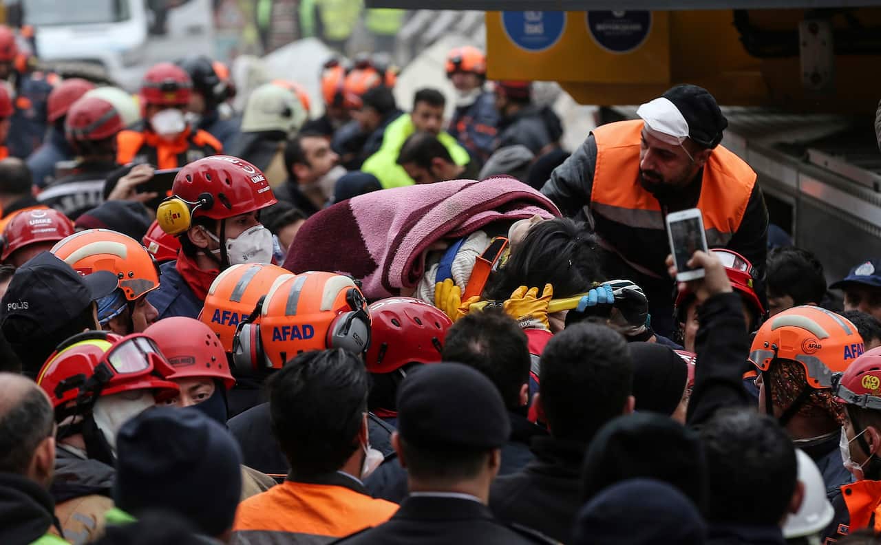 Rescue workers carry 5-year old girl Havva Tekgoz, after she was pulled from the rubble of an eight-storey building, some 18-hours after it collapsed.