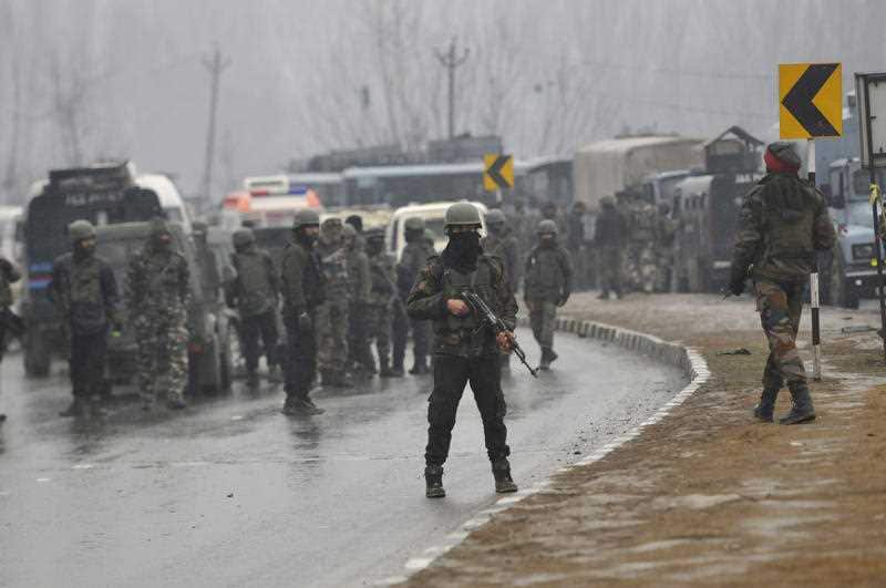 Security forces near the damaged vehicles