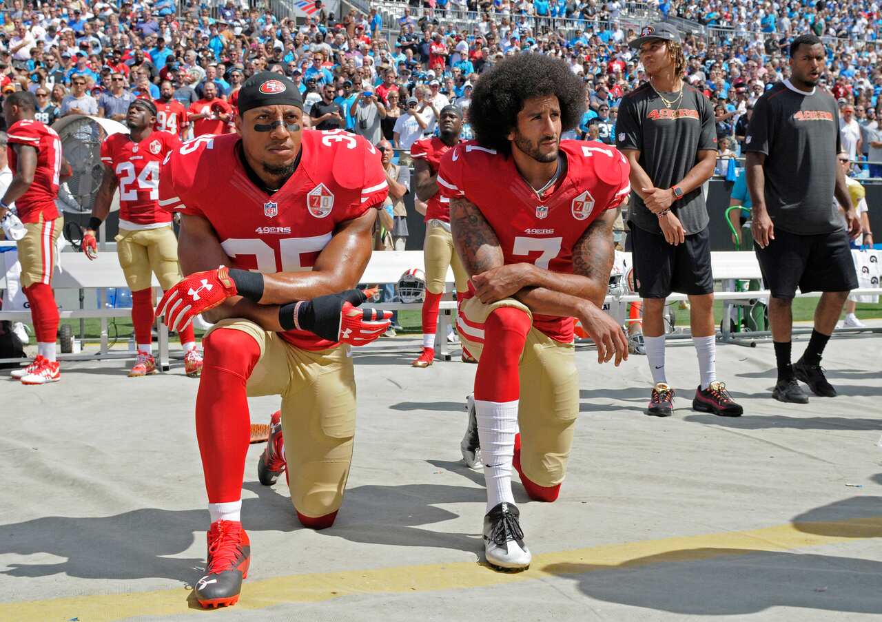 San Francisco 49ers' Colin Kaepernick and Eric Reid kneel during the national anthem before an NFL football game in 2016.