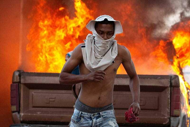 A person runs during clashes between opponents of Venezuelan President Nicolas Maduro and members of the Bolivarian National Guard