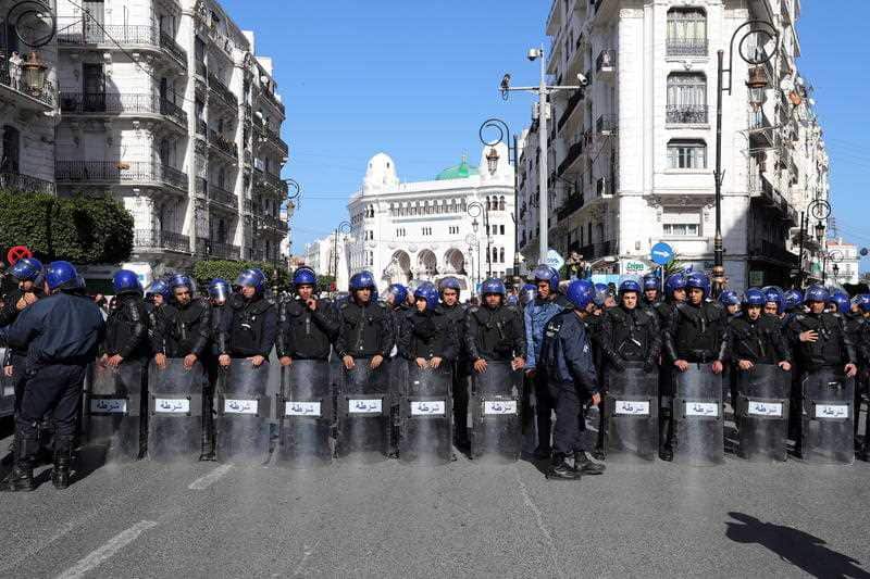 Police block the way in front of people protesting against the fifth term of Abdelaziz Bouteflika in Algiers.