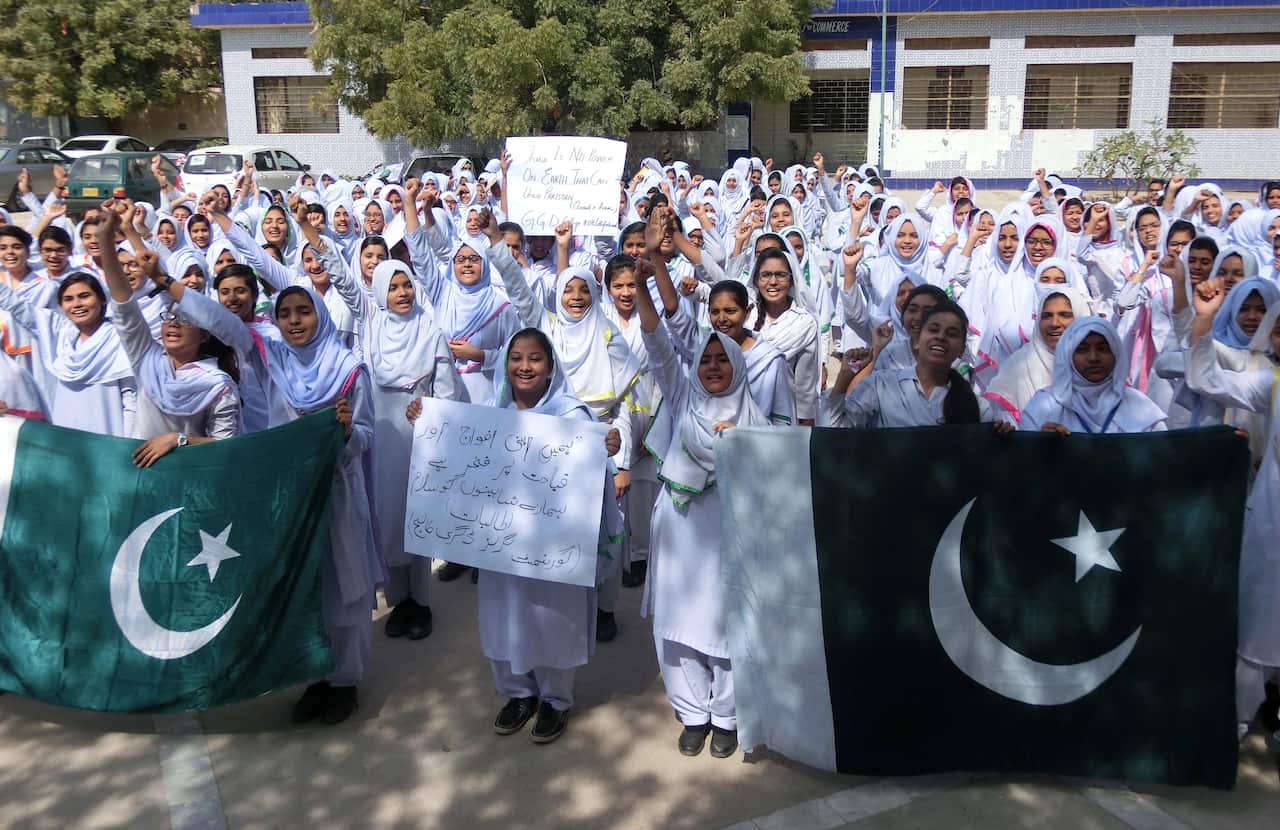Pakistani school girls hold national flags as they shout anti-India slogans during a protest in Hyderabad, Pakistan.