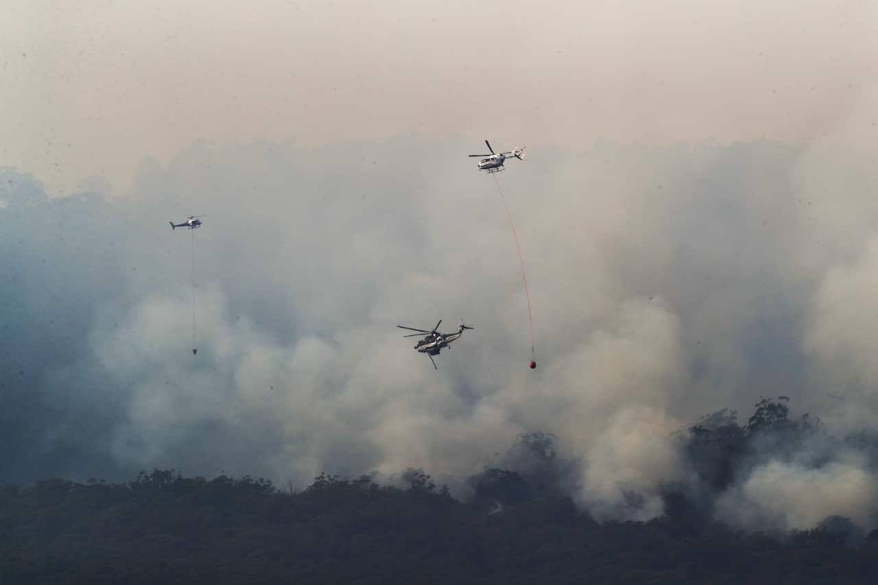 Helicopters drop water on a bushfire near Yiinnar in Gippsland, Victoria. 
