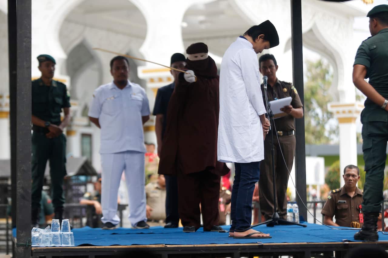 An Acehnese man faces a public caning punishment for having a sexual relationship without being married, in Banda Aceh.