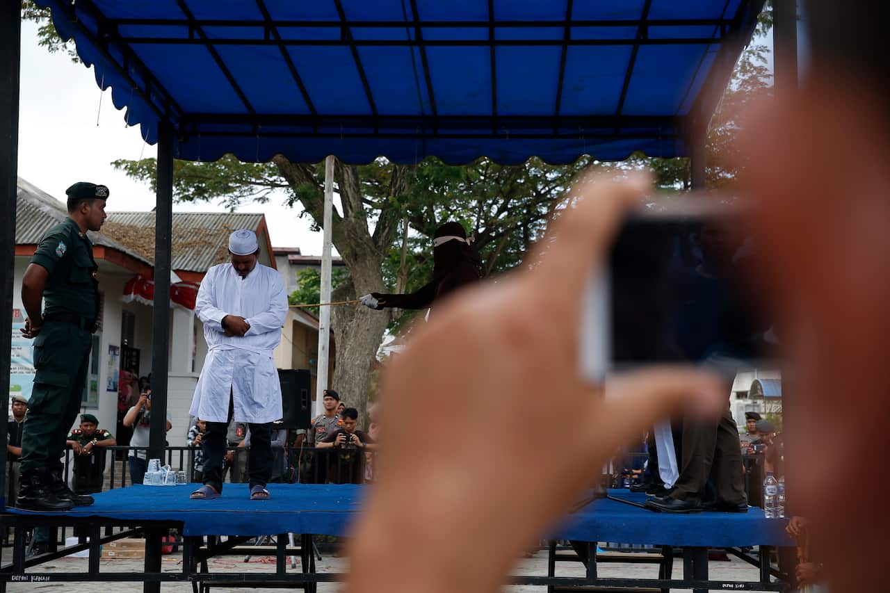 An Acehnese man faces a public caning punishment for having a sexual relationship without being married, in Banda Aceh.