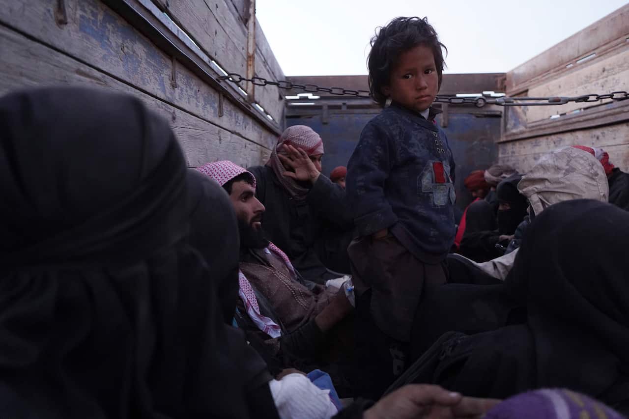 A child stands on the back of a truck after being evacuated out of the last territory held by Islamic State militants, outside Baghouz, Syria.