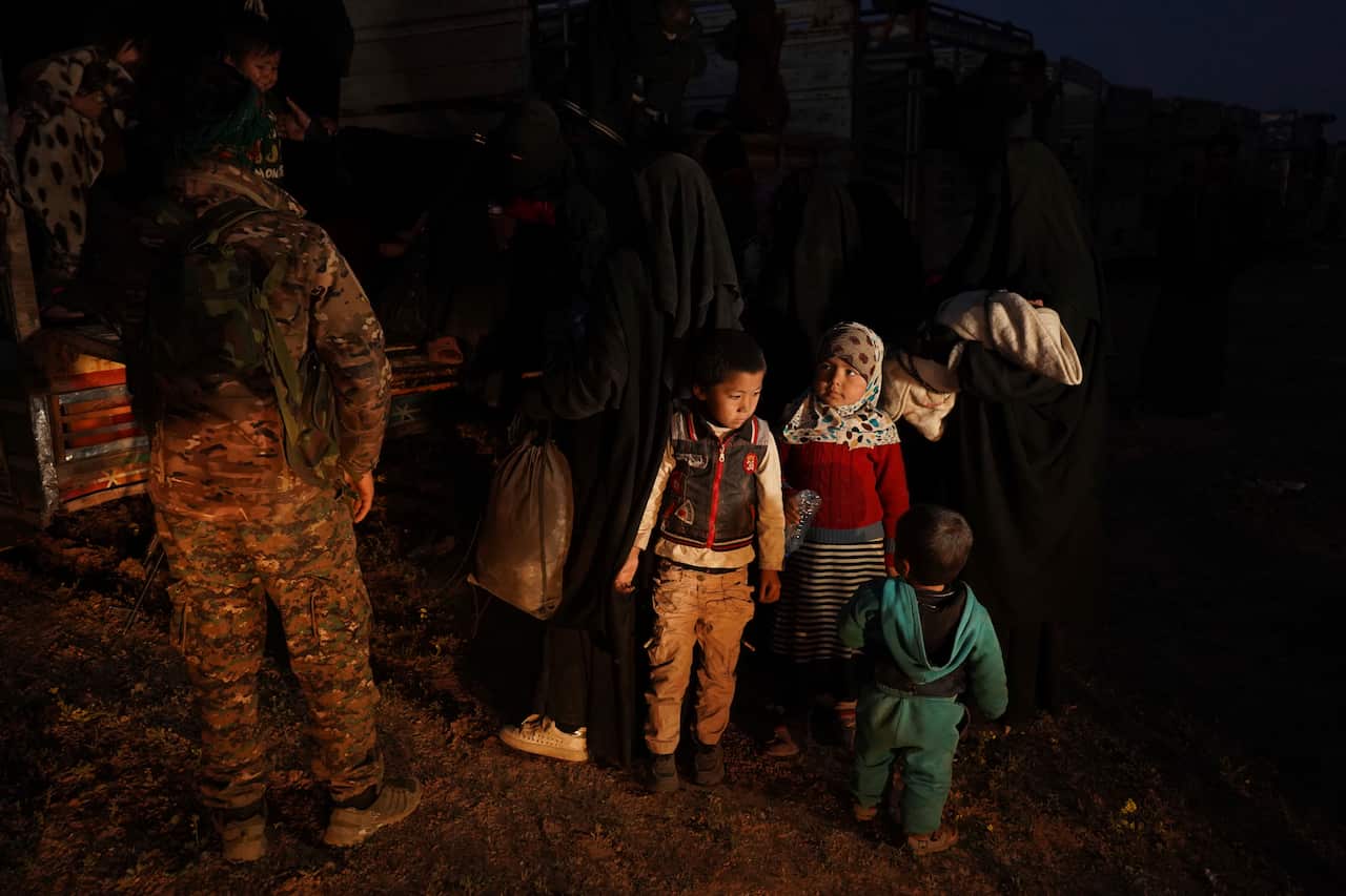U.S.-backed Syrian Democratic Forces (SDF) move women and children into a truck after being evacuated out of the last territory held by Islamic State militants.