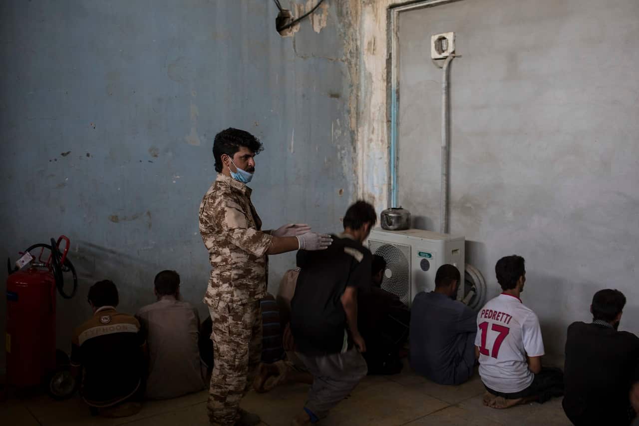 Kurdish security officer screens people in Hawija.