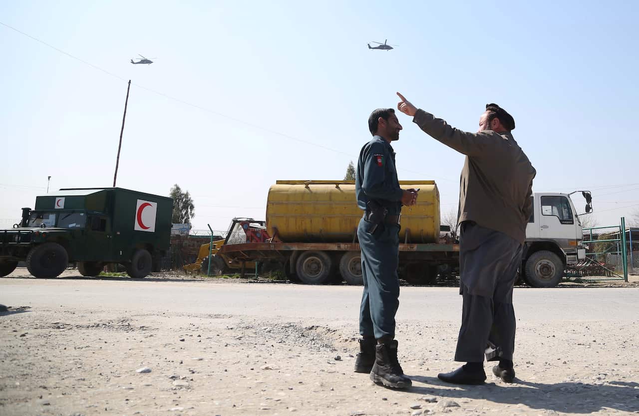 Military helicopters hover over Jalalabad Airport after an attack by militants, in Jalalabad, Afghanistan.