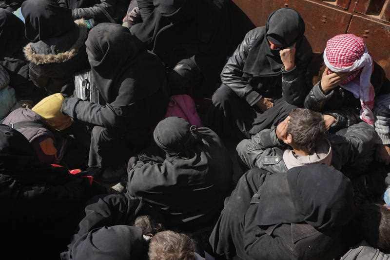 Men, women and children are evacuated in a truck. 