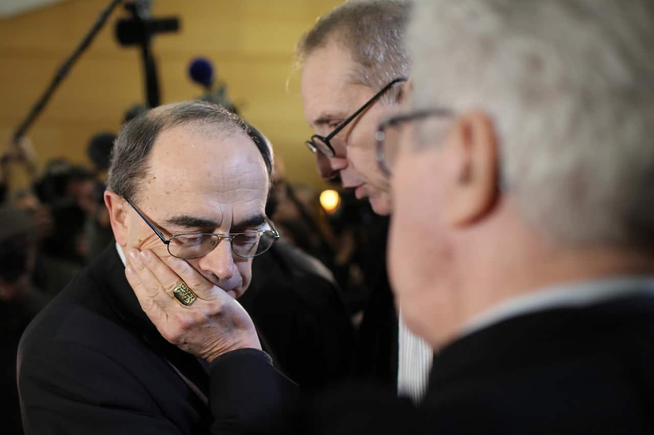 Cardinal Philippe Barbarin listens to his lawyers as he attends the start his trial, in Lyon, central France. 