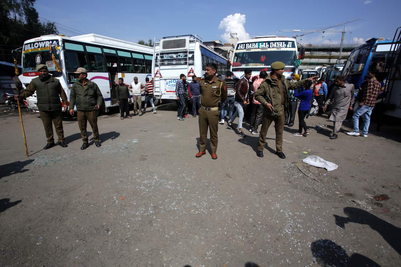 Indian paramilitary soldiers stand guard near a grenade blast site, at a general bus stand in Jammu, the winter capital of Kashmir, India.