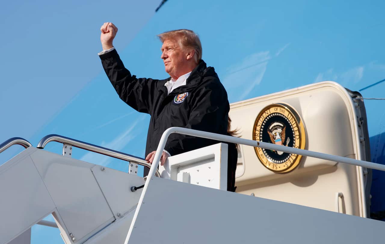 President Donald Trump gestures to people cheering on the tarmac as he arrives on Air Force One at Palm Beach International Airport, in West Palm Beach, Fla., Friday, March 8, 2019, en route to Mar-a-lago in Palm Beach, Florida.
