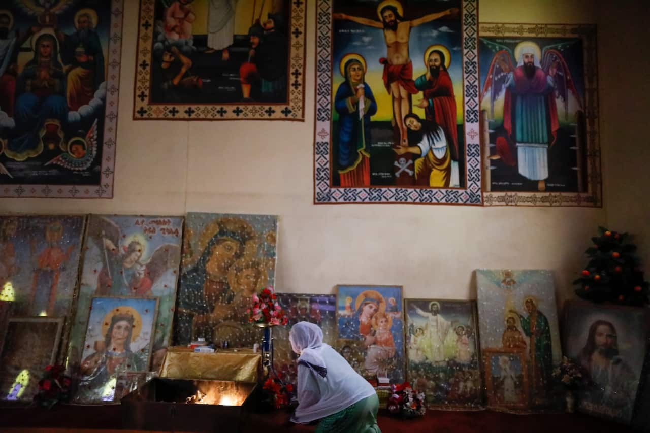 An Ethiopian woman lights a candle as she prays at an Ethiopian Orthodox church in Nairobi, a day after the Ethiopian Airlines flight ET 302 crashed.