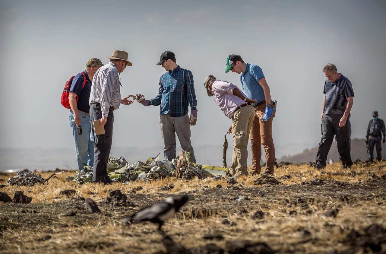 Foreign investigators examine wreckage at the scene where the Ethiopian Airlines Boeing 737 Max 8 crashed shortly after takeoff.