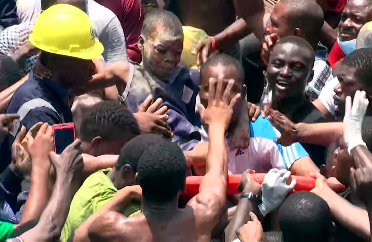 People help a child after he was rescued from a collapsed building in Lagos, Nigeria.