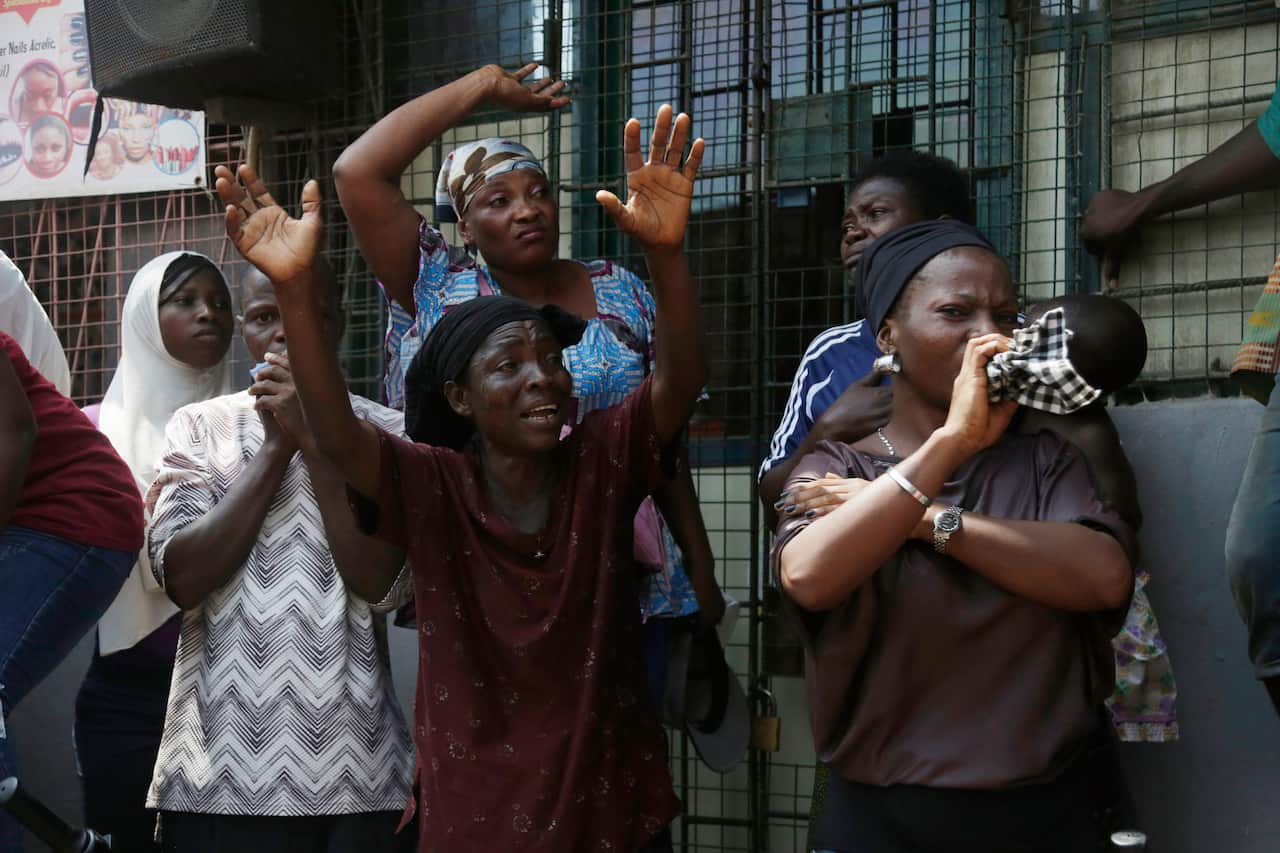 A woman cries as a body of child is recovered from the rubble of a collapsed building in Lagos, Nigeria.