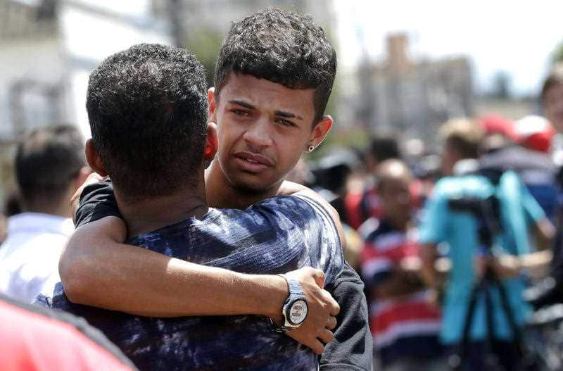 A former student is comforted by a friend