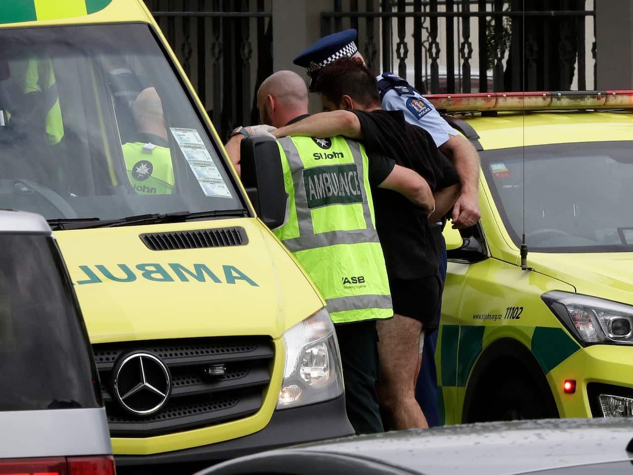 Police and ambulance staff help a wounded man from outside a mosque in central Christchurch, New Zealand, Friday.