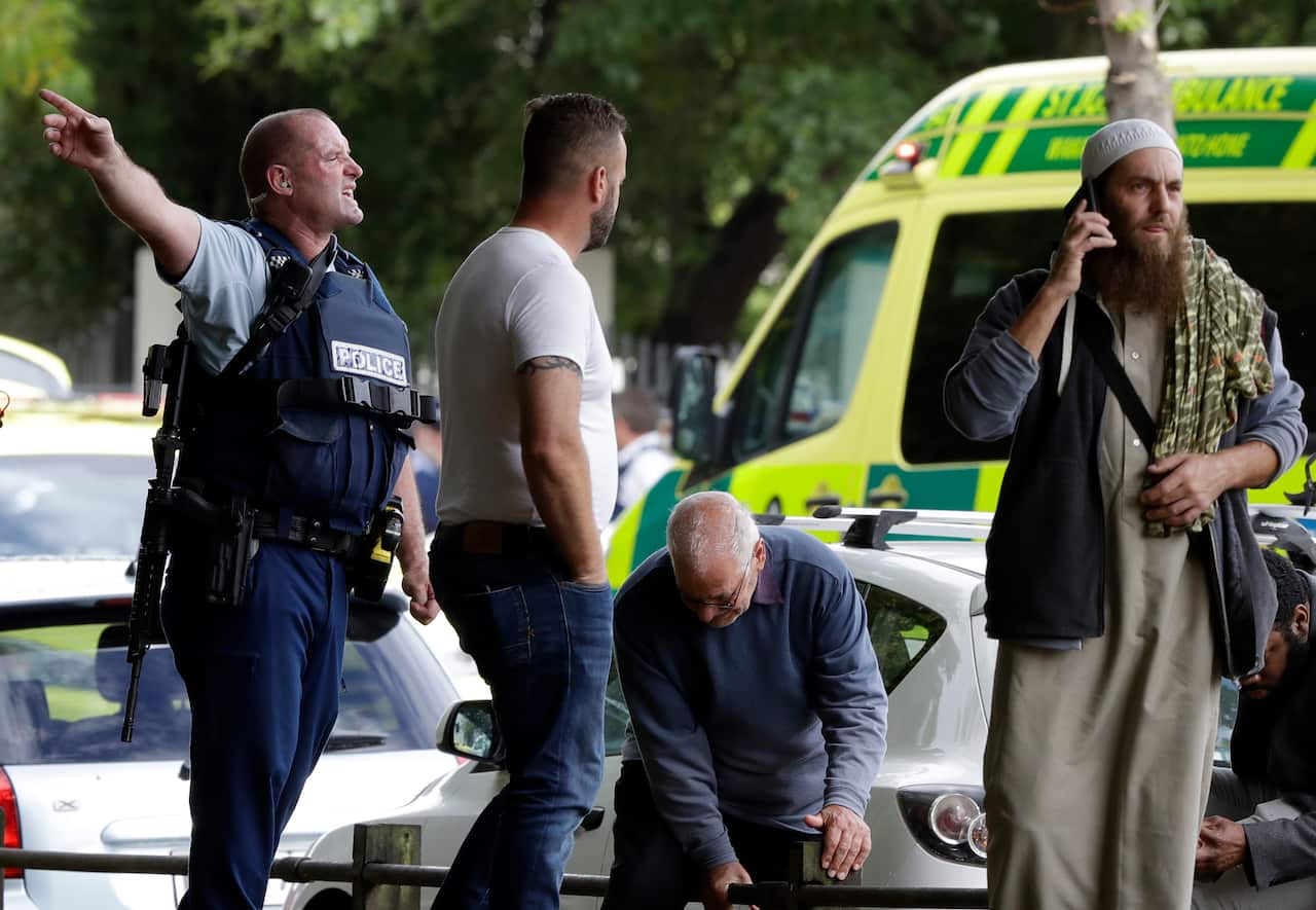 Police attempt to clear people from outside a mosque in central Christchurch, New Zealand, Friday.