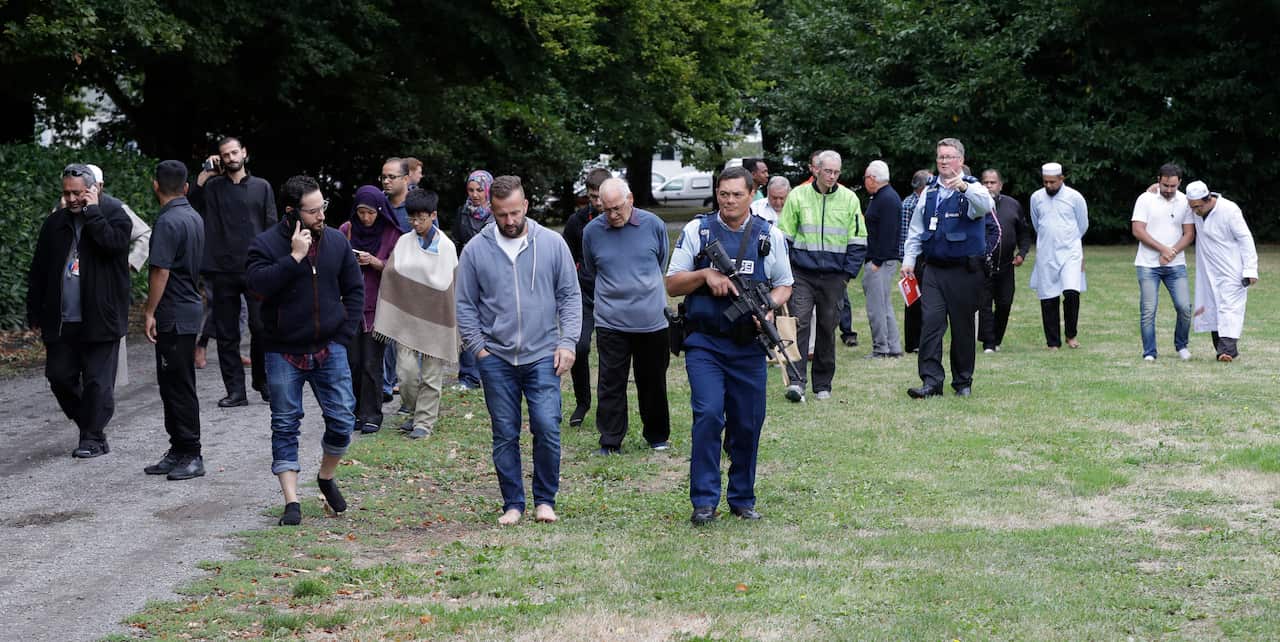 Police escort witnesses away from a mosque in central Christchurch.