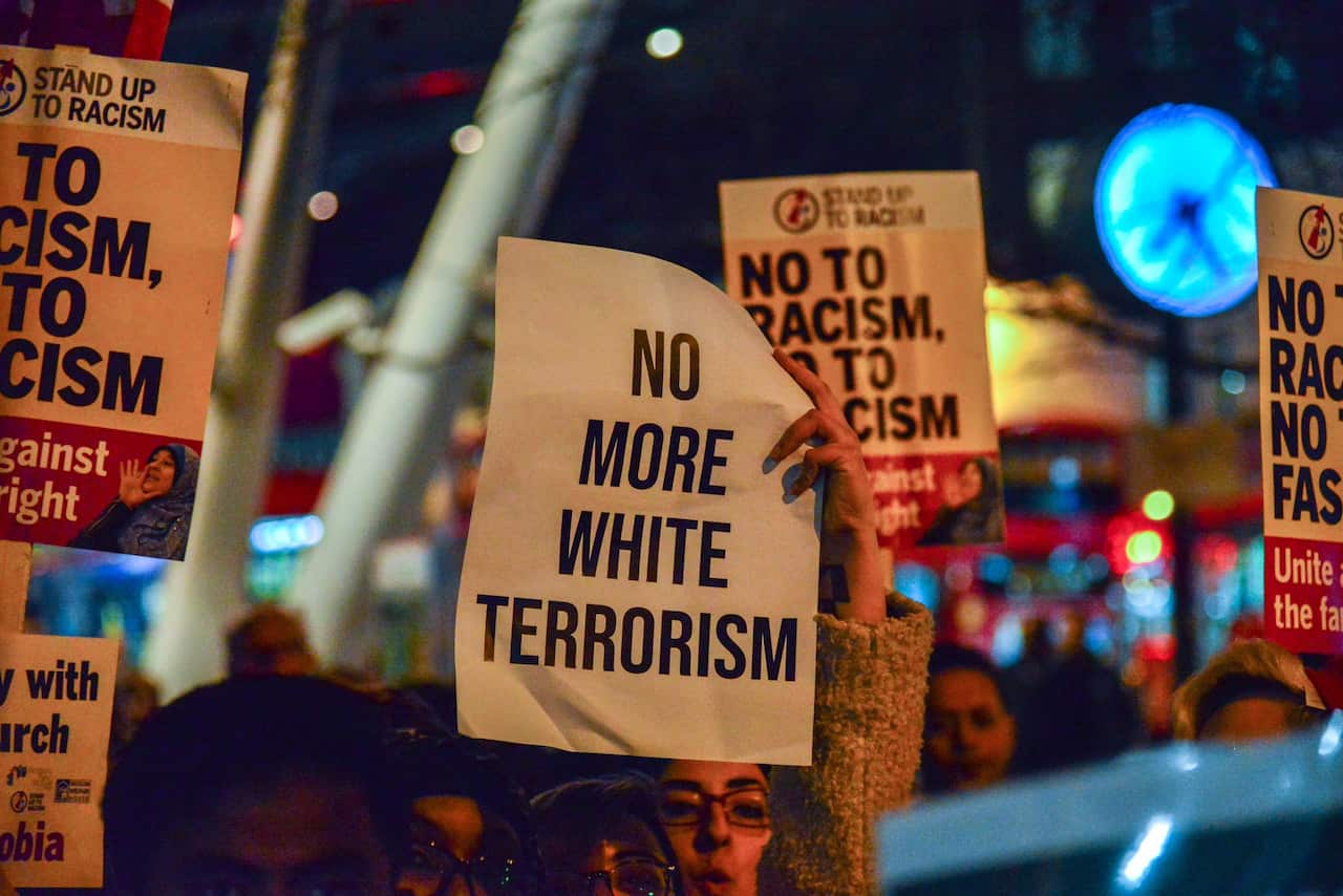 A women holds a sign reading "No more white Terrorism" at a rally close to Finsbury Park Mosque in London