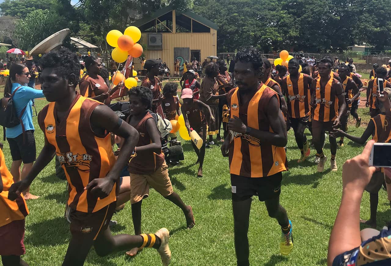 The Tapalinga Superstars run onto the field for the Tiwi Islands football grand final last year.