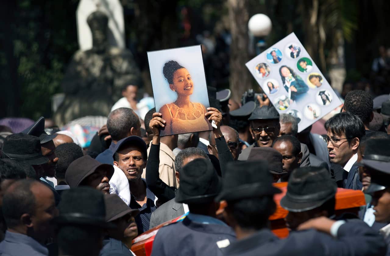 Relatives hold photographs of the victims at a mass funeral ceremony and procession held for the Ethiopian victims of the Ethiopian Airlines crash.