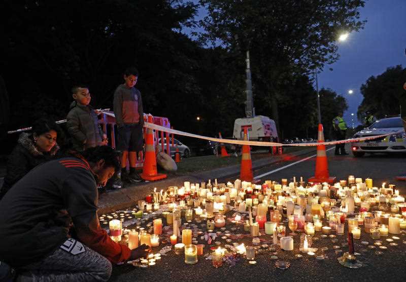 A mourner lights a candle during a vigil to commemorate victims of Friday's shooting, outside the Al Noor mosque in Christchurch.