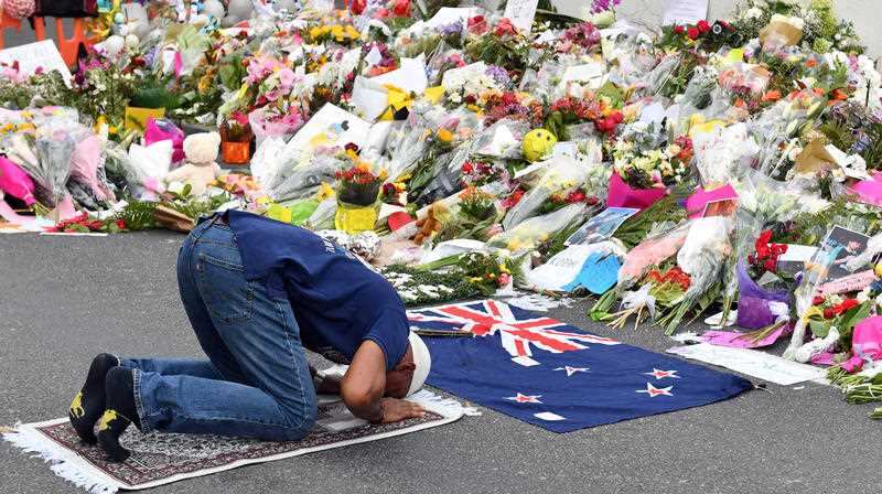 A muslim worshipper prays at a makeshift memorial at the Al Noor Mosque