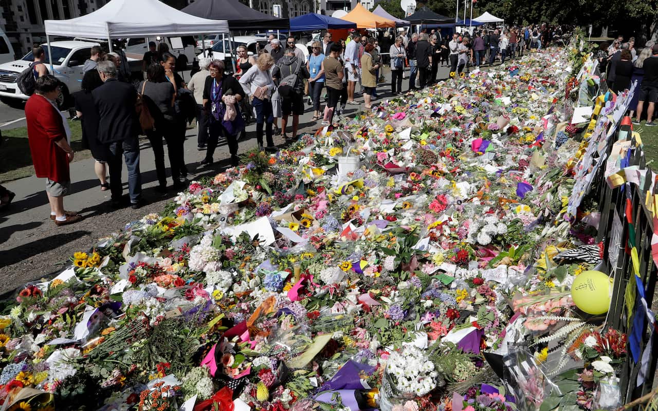 People view messages at a floral tribute at the Botanical Gardens in Christchurch, New Zealand.